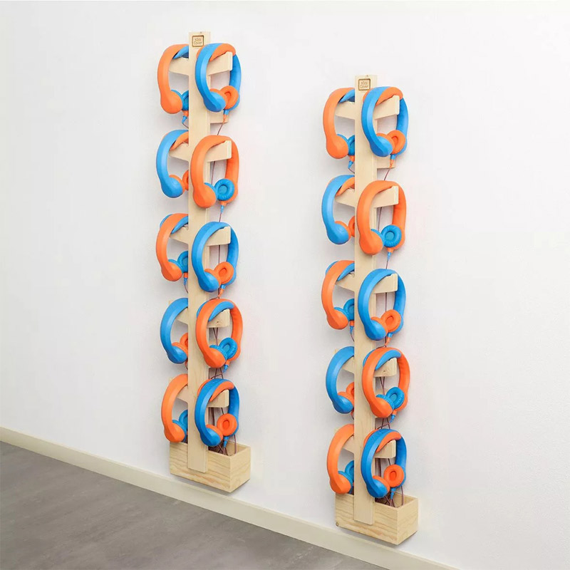 Deux supports muraux en bois avec plusieurs casques audio KidsCover orange et bleu